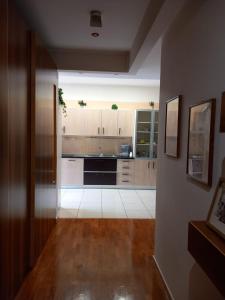 una cucina con armadietti bianchi e pavimenti in legno di Le Stanze di Nonna Lina a Pagani
