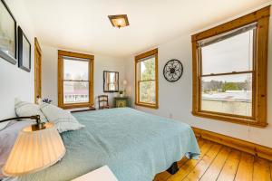ein Schlafzimmer mit einem Bett und zwei Fenstern in der Unterkunft Mackinaw City Getaway - 3 Mi to City Beach! in Mackinaw City