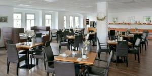 un comedor con mesas y sillas en un restaurante en Haus Hufeland, en Bad Salzungen