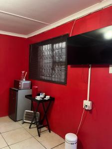 a red room with a table and a red wall at Grey house lodge in Pietermaritzburg
