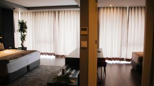 エディルネにあるRYS ホテルのベッドと大きな窓が備わるホテルルームです。