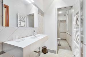 a white bathroom with a sink and a toilet at White Sea, Terre Marine in Riomaggiore +3 photos