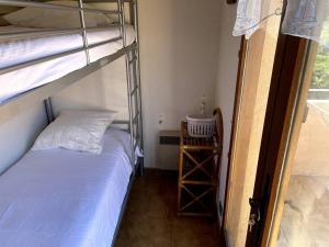 - une chambre avec des lits superposés et une échelle menant à un lit superposé dans l'établissement Appartement familial - accès plage + piscine, au Lavandou