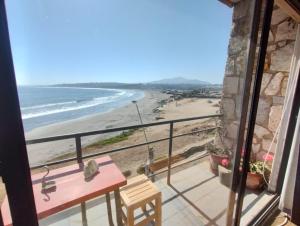 einen Balkon mit einem Tisch und Strandblick in der Unterkunft Pingüino en la roca - Concón in Concón