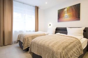 Dos camas en una habitación con ventana. en Luxury Saarbrücken 3, en Saarbrücken