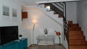 a dining room with a glass table and a staircase at GEINTUR TOLEDO EXCLUSIVE HERITAGE in Toledo