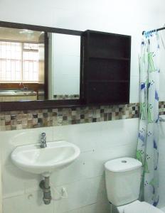 a bathroom with a sink and a toilet and a mirror at Roma House N- suite Campin Movistar Ministerios Simón Bolivar in Bogotá