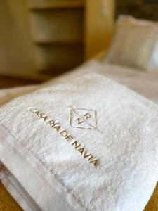 ナビアにあるCasa Ría de Naviaのベッドの上に白いタオル(ウェルカムマット付)