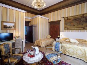 a bedroom with two beds and a table and chairs at Hotel Corte dei Greci in Venice