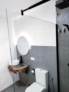 uma casa de banho com um WC branco e um lavatório. em La Martela de Fuentes Casa de diseño rural em Fuentes de León