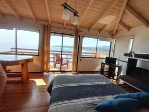 1 dormitorio con cama y vistas al océano en Pingüino en la roca - Concón, en Concón