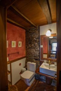a bathroom with a white toilet and a sink at Casa Ría de Navia in Navia