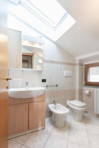 een badkamer met een wastafel, een toilet en een dakraam bij Civenna Lake View by Wonderful Italy in Civenna