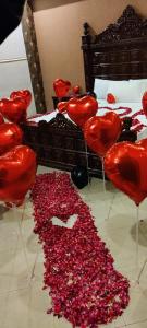 eine Gruppe roter Herzen auf dem Boden neben einem Bett in der Unterkunft Hotel New Star View in Bahawalpur