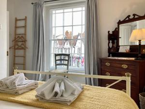 a bedroom with a bed with a mirror and a window at House On The Hill in Framlingham