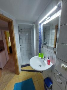 a bathroom with a white sink and a shower at Ferienwohnung Glasperlenfloh in Ilmenau