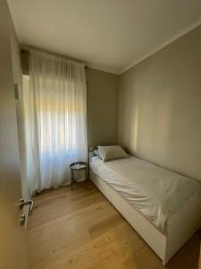 um pequeno quarto com uma cama e uma janela em Via Scernio 2 PT em Bonassola