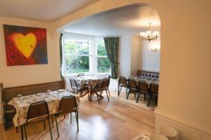 a dining room with tables and chairs and a large window at Llandudno Hostel in Llandudno