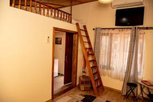 a room with a staircase and a television on the wall at Casa Ecaterina 2 Mai in 2 Mai