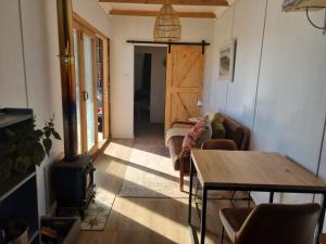 Una sala de estar con un sofá y una estufa de leña. en Countryside Container Home, en Baardskeerdersbos 8 fotos más
