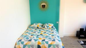 a bedroom with a bed with a blue wall at Appartement La Rotonde in Montluçon