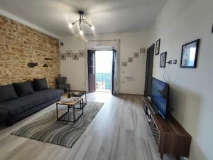 a living room with a couch and a tv at Dommu de Anna Murru in Baunei