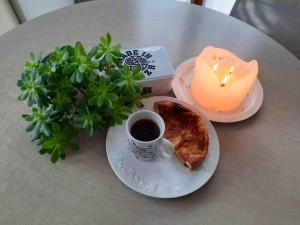 einen Tisch mit einer Kerze und einem Teller mit einer Tasse Kaffee und Toast in der Unterkunft Kerletty, la mer, les embruns, à 250 m des plages in Plouguerneau