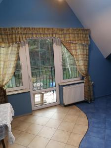 a room with two windows with curtains on them at Pokoje Gościnne Gdańska 21 J in Świnoujście