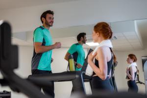 a group of people exercising on a treadmill in a gym at Aparthotel Adagio Access Kiel in Kiel