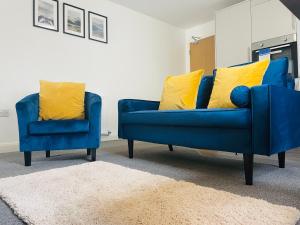 a blue couch and two yellow pillows in a living room at Westcliffe Apartments in Southport