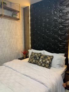 a bedroom with a large bed with a black headboard at Batam Three Bedrooms Apartment - One Residence 2AG - in Batam Center