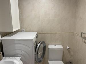 a small bathroom with a toilet and a sink at Residencial Mar de Denia 2 in Denia +6 photos