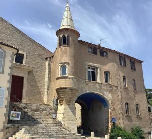 Un ancien bâtiment avec une tour en haut dans l'établissement LES AMOUREUX DU VIEUX LAVOIR T3 Hyères Médiéval, à Hyères