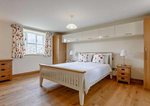 um quarto com uma grande cama branca e uma janela em Orchard View em Gilwern