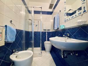 baño azul y blanco con lavabo y aseo en Hotel Villa Grazia, en Cesenatico