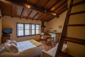 a bedroom with a bed and a table and a kitchen at Casa Ría de Navia in Navia