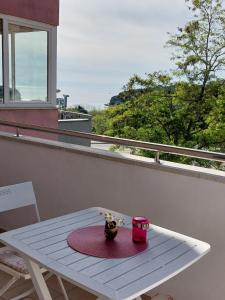 einen weißen Tisch auf einem Balkon mit einem Tisch und einem Korb in der Unterkunft Apartman Suzy in Pula