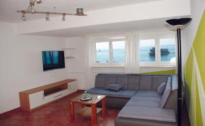uma sala de estar com um sofá e uma televisão em Seehotel ZUR MÜNZ em Meersburg