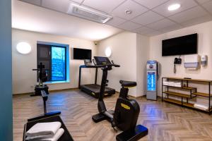 um ginásio com equipamento de exercício e uma televisão de ecrã plano em ibis Styles Kiel City em Kiel