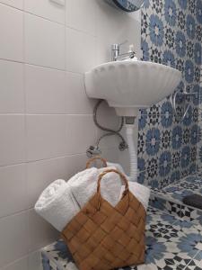 帕拉利亞卡泰里尼斯的住宿－Olympian Chalet，一间带水槽、毛巾和篮子的浴室
