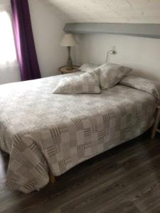 1 dormitorio con 1 cama con edredón blanco en Laporte en Luz-Saint-Sauveur