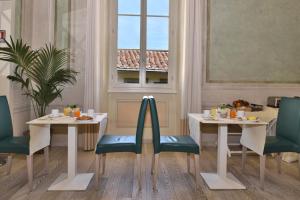 Residenza Fiorentina في فلورنسا: مطعم بطاولتين وكراسي ونافذة
