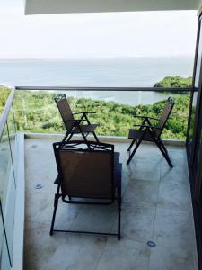 two chairs sitting on a balcony looking out at the ocean at Luxury Apartment in Ocean Pavillion Hotel in Cartagena de Indias