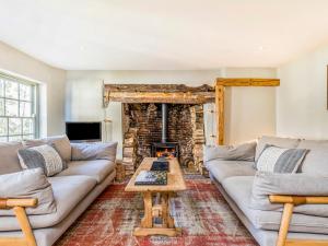 a living room with a couch and a fireplace at Charming Downland Cottage - Pass the Keys in Chichester