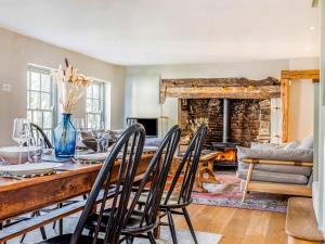 a dining room with a table and chairs and a fireplace at Charming Downland Cottage - Pass the Keys in Chichester