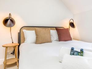 a bedroom with a white bed with pillows at Charming Downland Cottage - Pass the Keys in Chichester