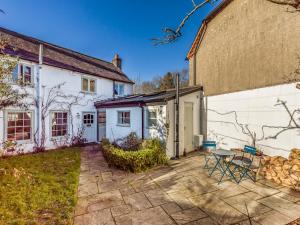 a white house with a table and chairs in a yard at Charming Downland Cottage - Pass the Keys in Chichester