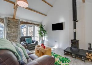 a living room with a couch and a wood stove at Gwel y Cambria - Cambrian View in Rhostie