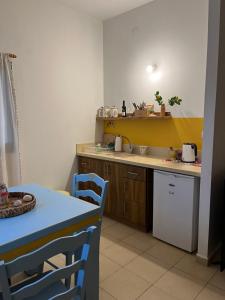 una cocina con fregadero y una mesa con una mesa azul en Mountainside experience in Amirim en Amirim