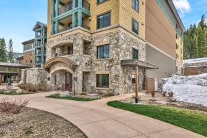a large stone building with a sidewalk in front of it at Constellation Residences in Truckee